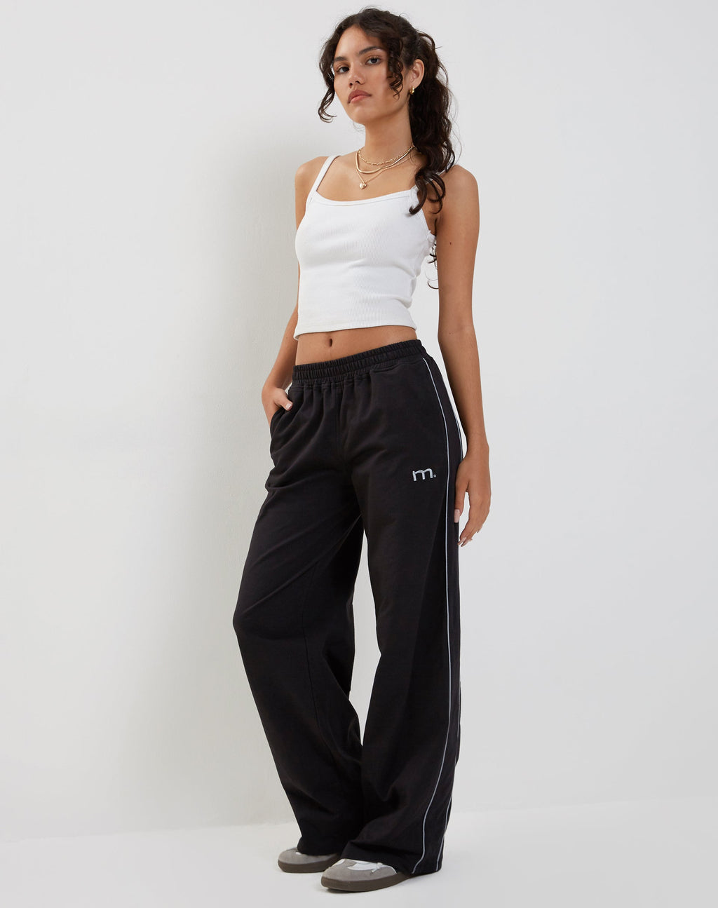 Pantalon de jogging à jambes larges Benton en noir avec passepoils gris foncé et broderie 'M'.