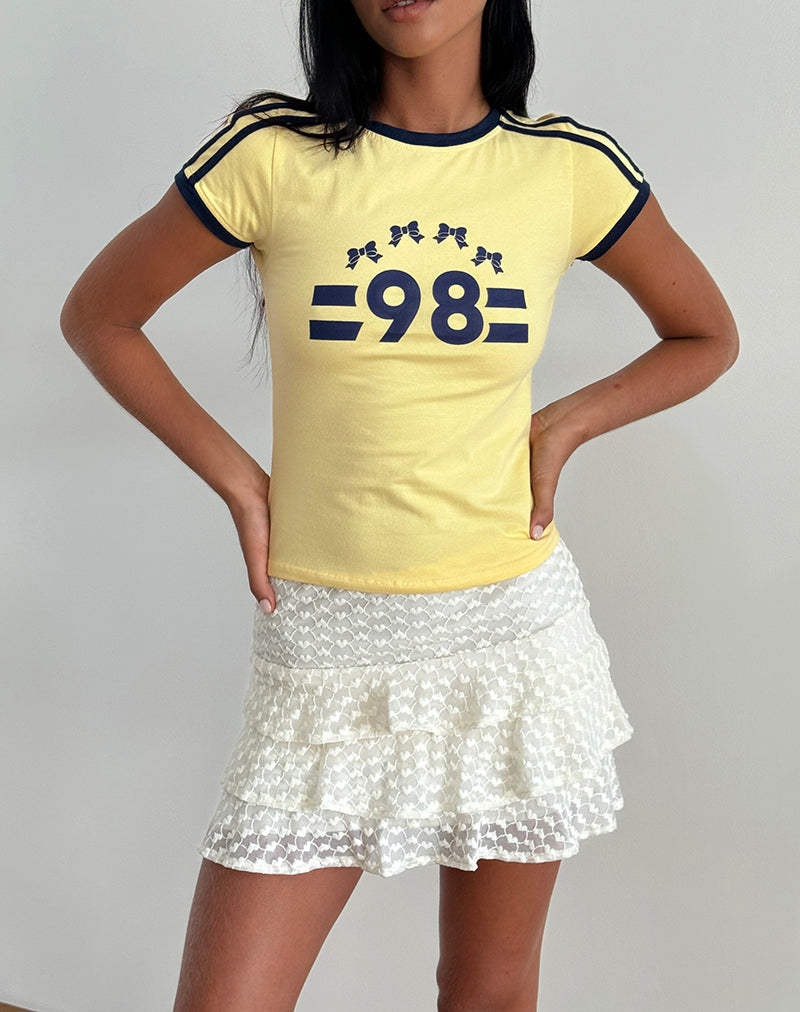 Image du tee-shirt Salda en limonade avec reliure marine et emblème '98'.