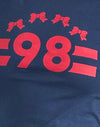 Bleu marine avec bande rouge adrénaline et emblème '98'.