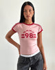Image du tee-shirt Salda en Pink Lady avec la fixation rouge Adrenaline et l'emblème '98'.